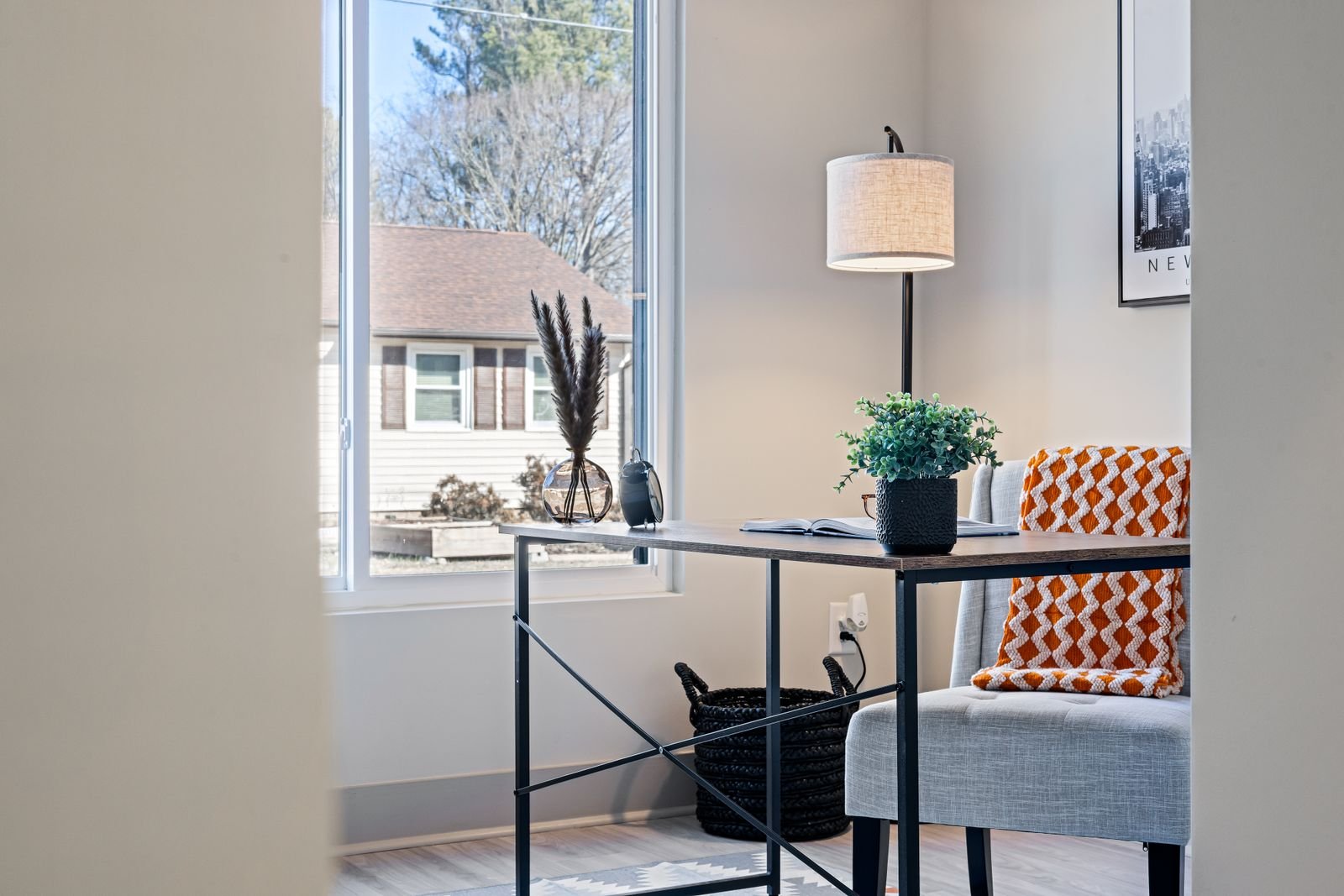 Minimalist home office with a desk, lamp and chair beside a window